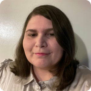 Woman with medium brown hair and beige blouse