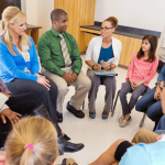 a group of families and educators sit around in a circle for an informational school session