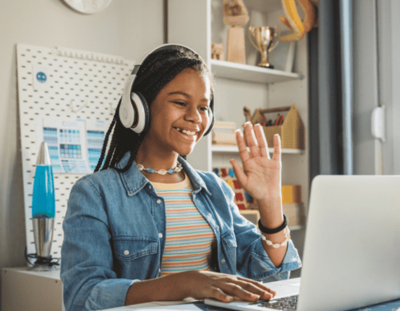 female student waving at a laptop