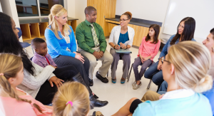 a group of families and educators sit around in a circle for an informational school session