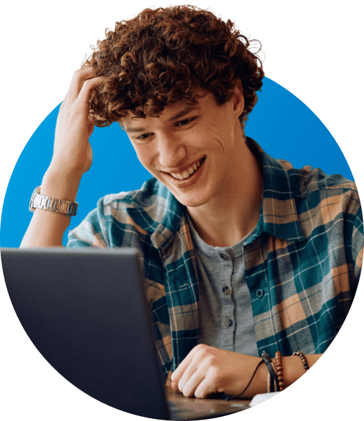 male student in plaid shirt working on a laptop