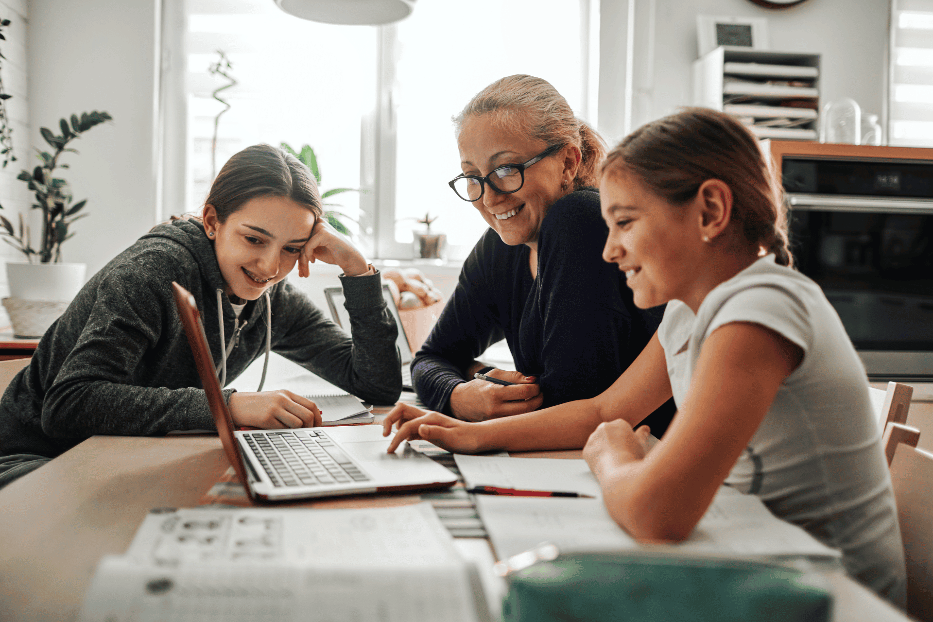 kids studying with their parents over a laptop at home