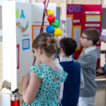 Elementary students showcasing projects at a school tour for choice week.