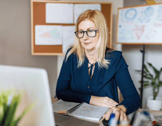 Blonde teacher working at her desk on a laptop