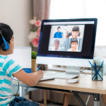 A young student joins his class virtually in a synchronous classroom setting. 