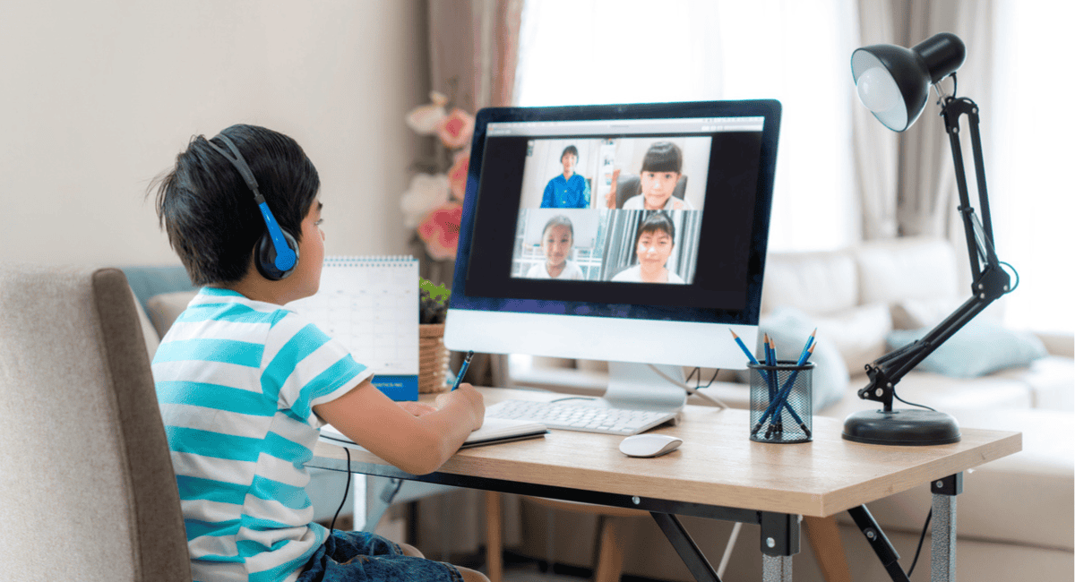 A young student joins his class virtually in a synchronous classroom setting. 