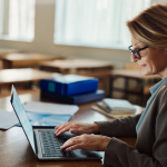 A teacher uses her laptop to input student data into an SIS Suite.