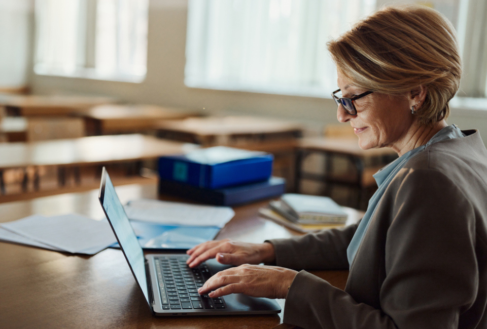 A teacher uses her laptop to input student data into an SIS Suite.