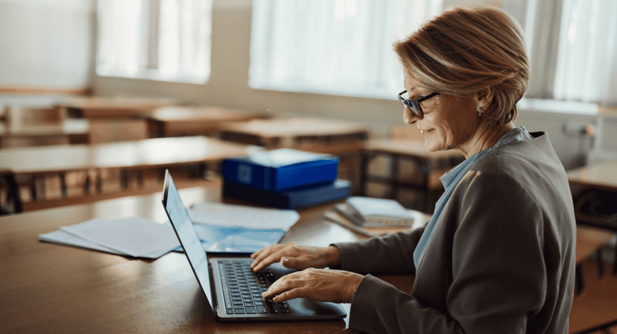 A teacher uses her laptop to input student data into an SIS Suite.