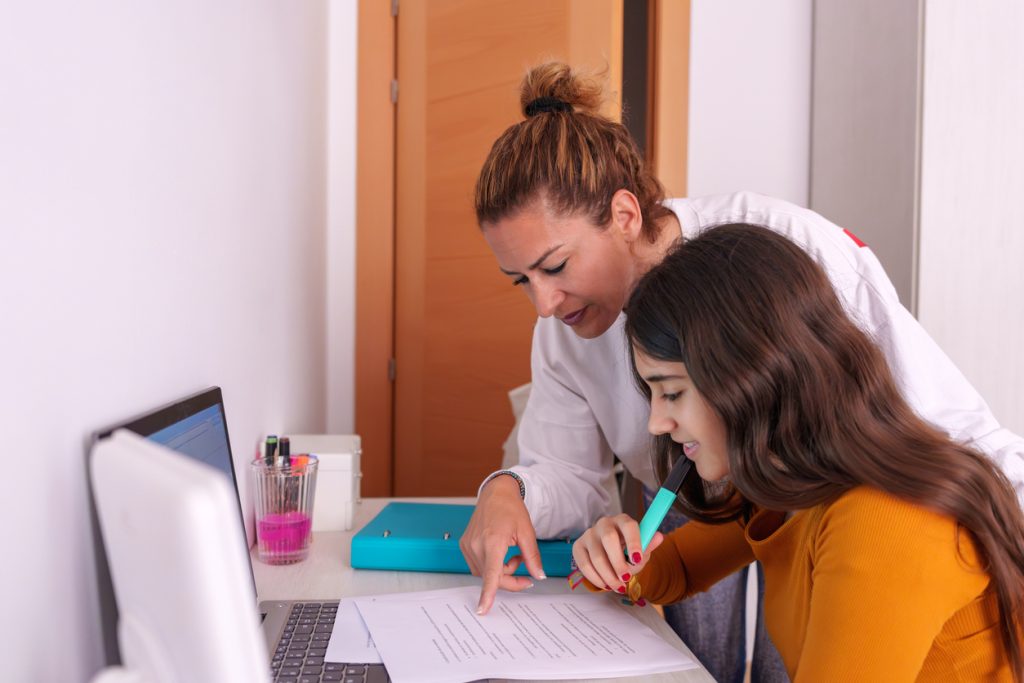 A mom and daughter fill out admissions paperwork for charter school enrollment.