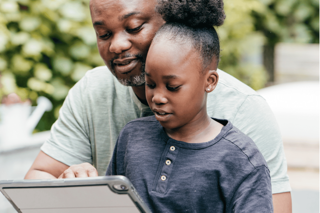 father-engages-with-daughter-with-school-on-tablet